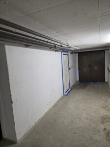 Innenraum mit Rohrleitungen und vorbereiteter Absperrung für Asbestsanierung