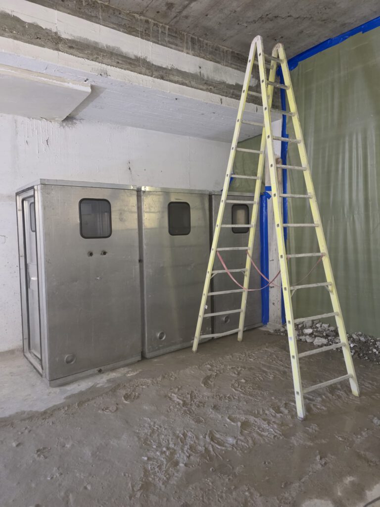 Leitern vor Sanitärschränken in einem Raum während der Asbestsanierung
