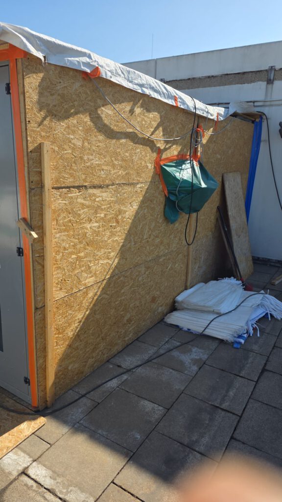 Provisorische Holzwand zur Abgrenzung bei Asbestentsorgung
