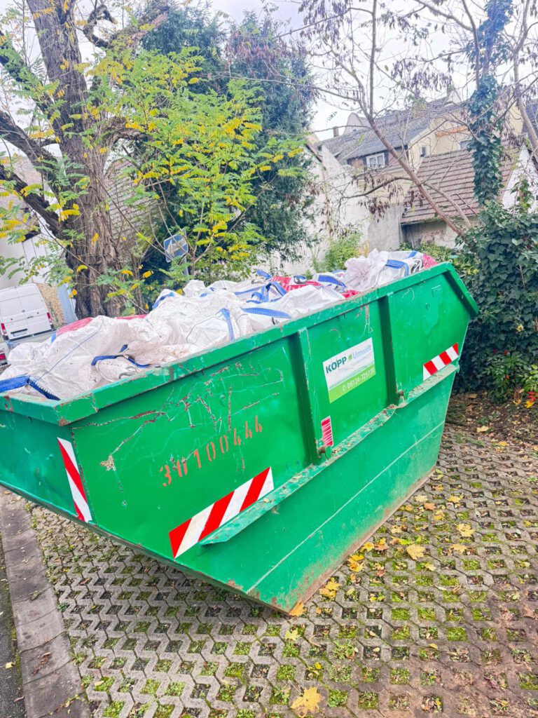 Grüner Container mit Säcken für Asbestentsorgung im Außenbereich