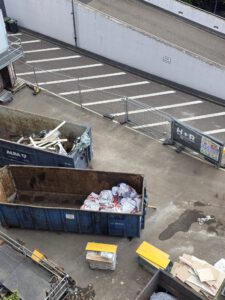 Offene Container mit Säcken und Baumaterial für Asbestentsorgung