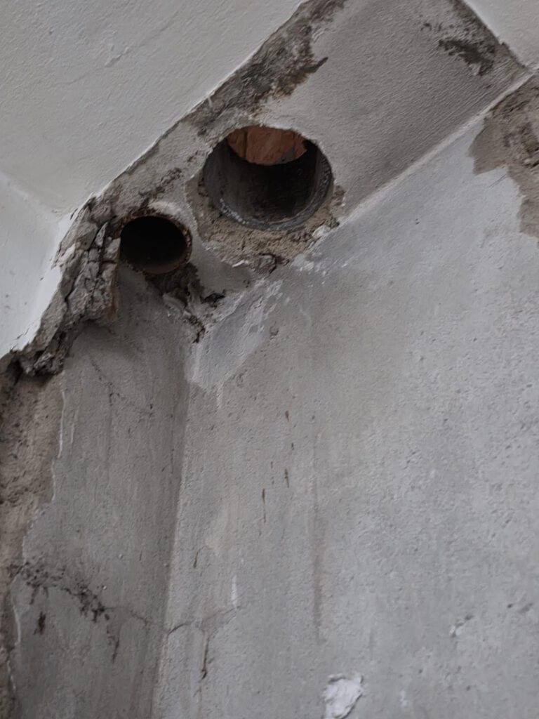 Wand mit geöffneten Bohrungen bei Asbestdemontage