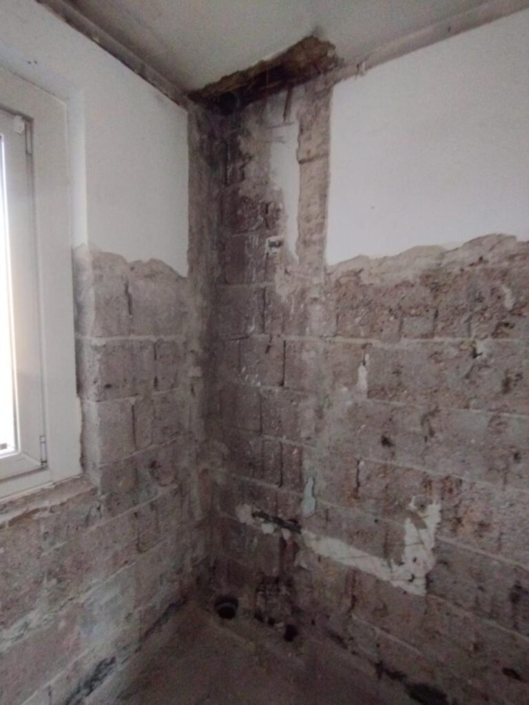 Raumecke mit freigelegter Wand nach Asbestentfernung