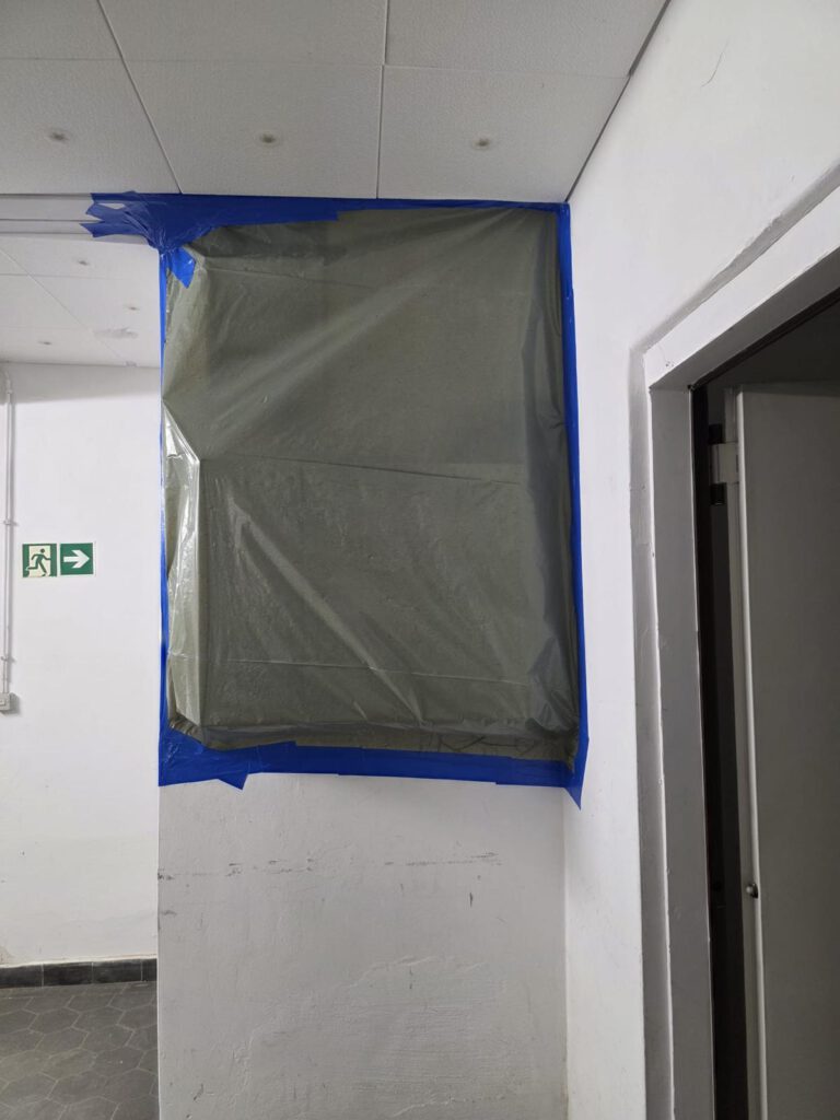 Wandöffnung mit Absperrfolie bei Asbestsanierung in Innenraum